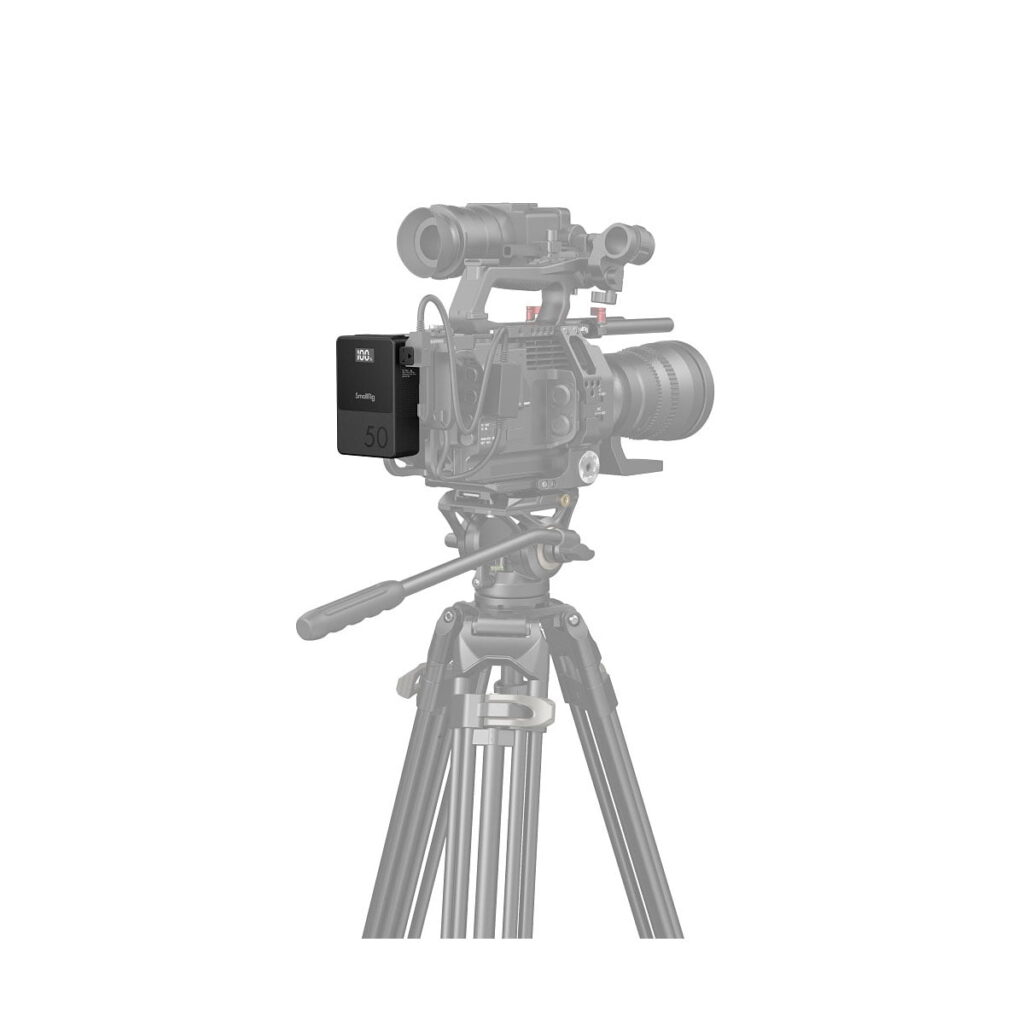 SmallRig_VB50_mini_V-Mount_Battery_3579_008 The professional video camera on a tripod appears mostly in pale grey, and the camera is fitted with a fully visible SmallRig 3579B V-Mount Battery Mini VB50 in black, marked 50. The camera is in colour.