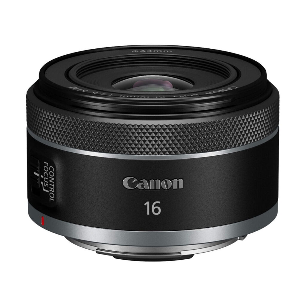 canon_rf_16mm_f28_03 Mustan ja hopean värinen Canon RF 16mm f/2.8 STM -objektiivi, jossa on tarkennuksen/ohjauksen kytkin ja kuvioitu tarkennusrengas, näkyy valkoisella pohjalla.