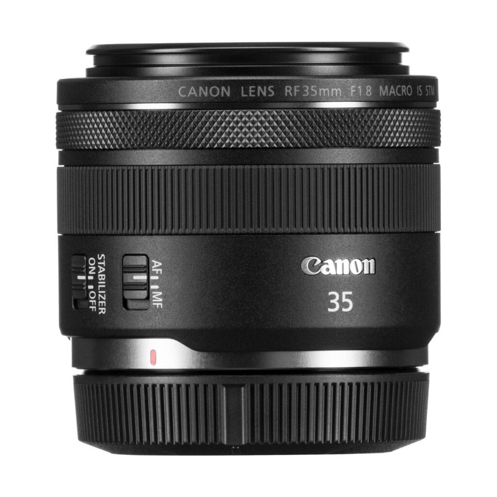 canon_rf_35mm_macro_02 A Canon RF 35mm f/1.8 Macro IS STM -objektiivi, jossa näkyvät ohjauskatkaisijat ja tuotemerkki, on esillä valkoista taustaa vasten - nyt 65 € alennus.