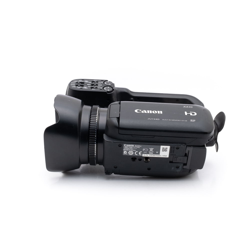 canon_xa10-3 Käytetty Canon XA10 (sis.ALV24%) -videokamera on kuvattu kyljellään valkoista taustaa vasten, jolloin objektiivi, ohjauspainikkeet, tuotemerkki ja tulo-/lähtöportit tulevat esiin.
