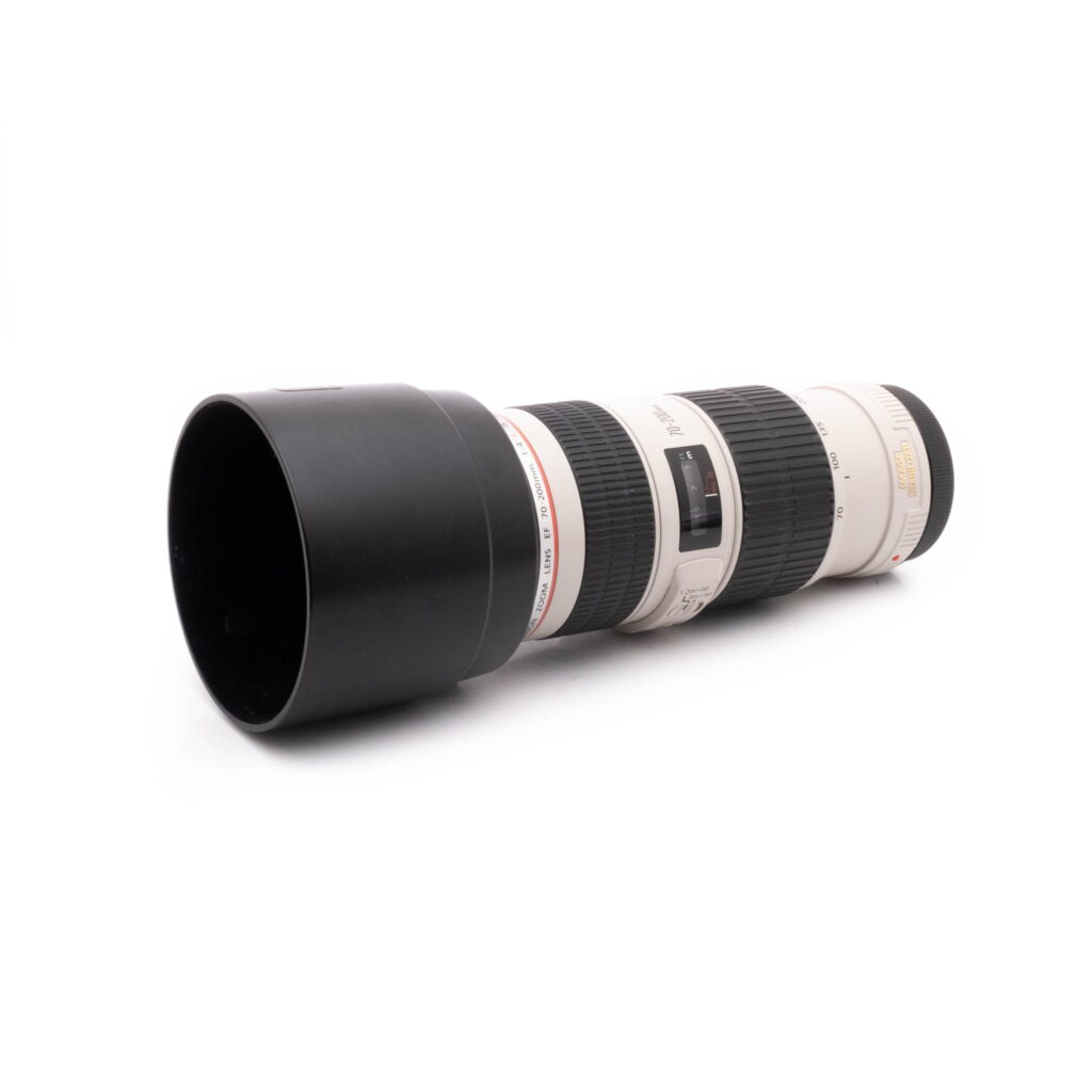 Canon EF 70-200 F4-1 Canon EF 70-200mm F4 IS USM - Käytetty valkoinen teleobjektiivi, johon on kiinnitetty musta huppu, valkoisella taustalla.
