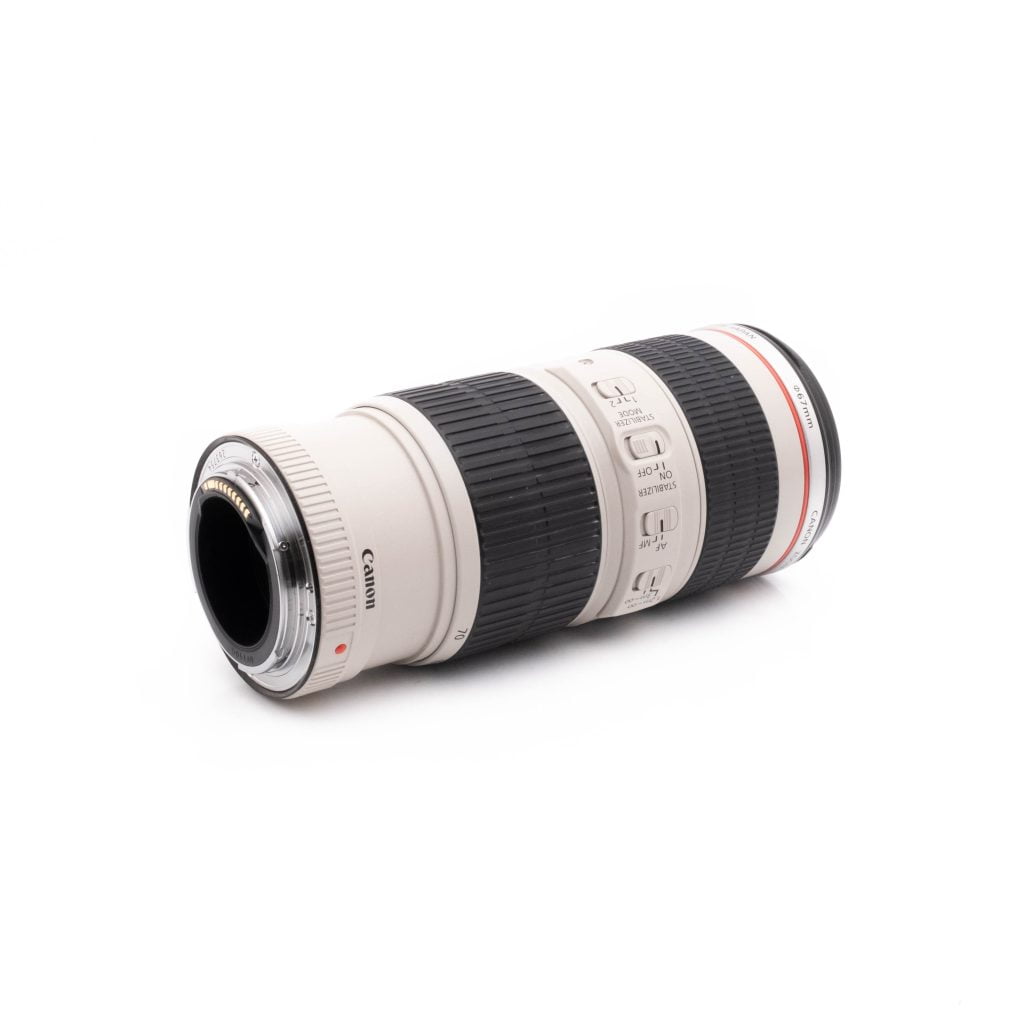 Canon EF 70-200 F4-3 Canon EF 70-200mm F4 IS USM (käytetty) valkoinen teleobjektiivi, jossa on musta kumikahva, säätökytkimet ja punainen rengas, on kuvattu kyljellään valkoista taustaa vasten.