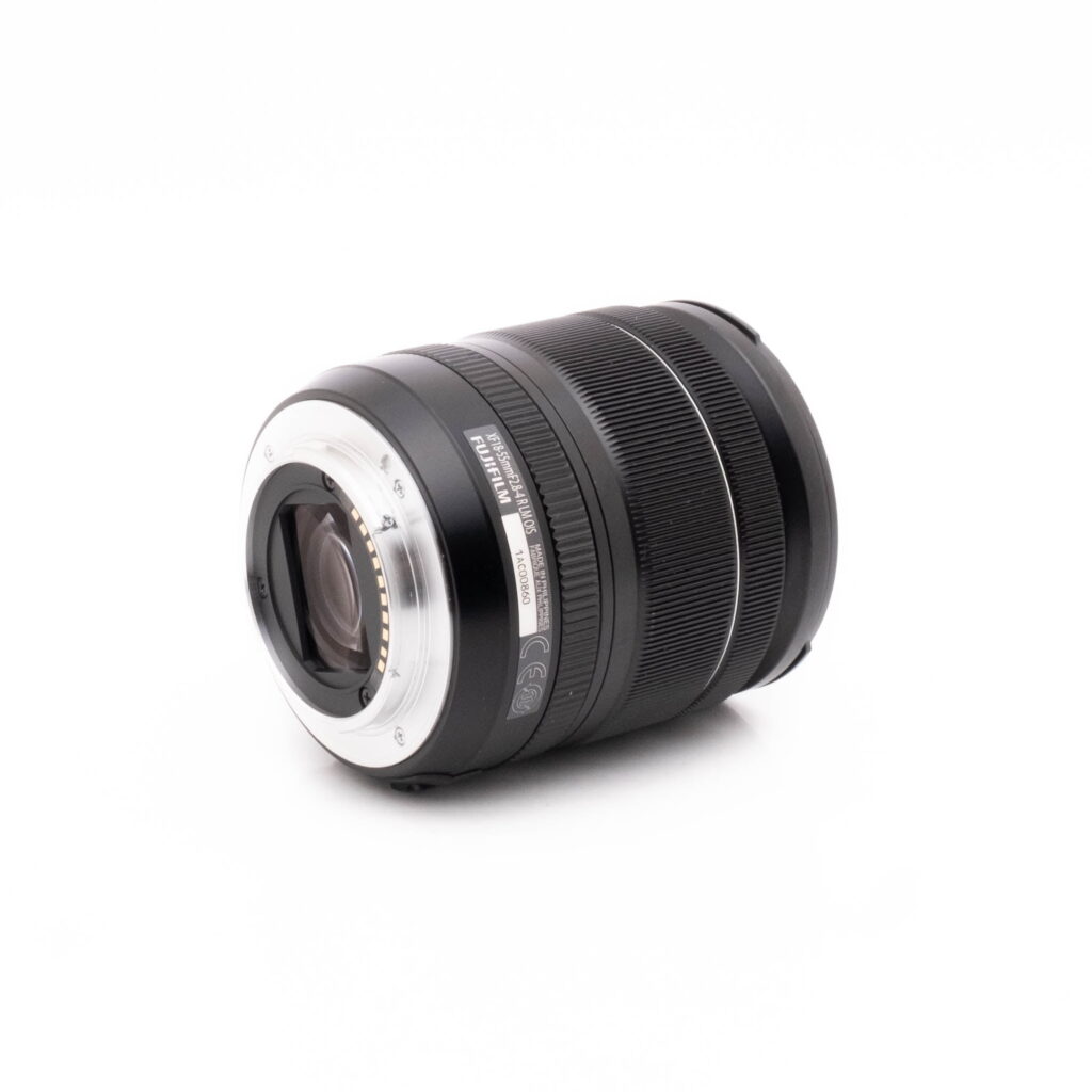 Fujifilm 18-55mm-3 Fujifilm X-S10 (SC 1189) - Käytetty on kuvattu valkoisella taustalla, jolloin sen musta objektiivirunko ja hopeinen metallirunko, jossa on näkyvät elektroniset koskettimet, korostuvat.