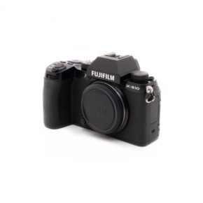 Fujifilm X-S10-1 Fujifilm X-S10 (SC 1189)- Käytetty digitaalikamera näkyy valkoisella taustalla. Mustaan kameraan ei ole kiinnitetty objektiivia, objektiivin kiinnityssuojus on paikallaan ja mallin nimi näkyy selvästi rungossa.