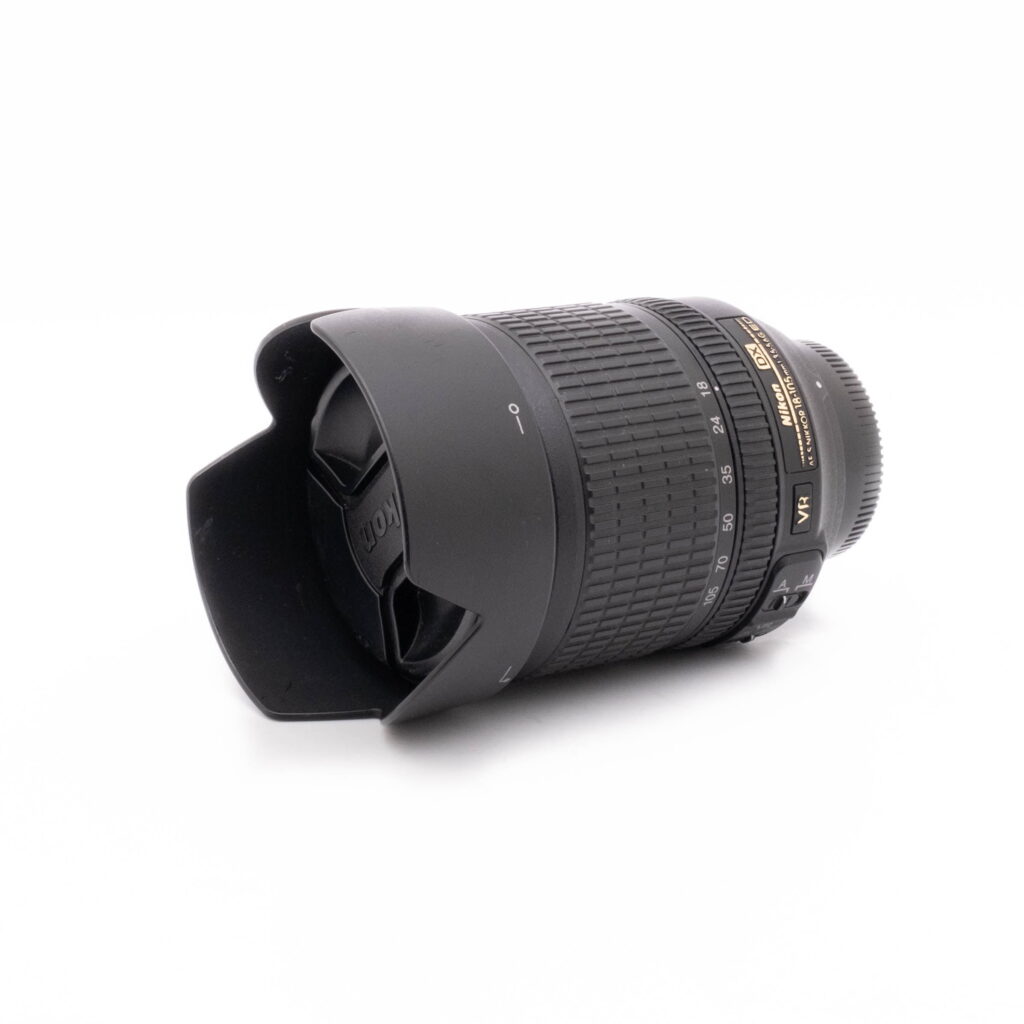 Nikkor 18-105-1 Canon EF 100-400mm f/4.5-5.6 L IS II USM - Käytetty musta DSLR-kameran objektiivi, jossa on terälehden muotoinen huppu ja polttovälin merkinnät valkoisella taustalla.