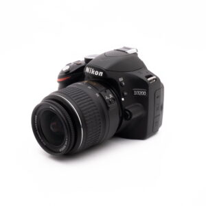 Nikon D3200 kit-1 Nikon D3200 + 18-55mm (SC 3378) - Käytetty kamera mustana kuvattuna kulmassa valkoisella taustalla.