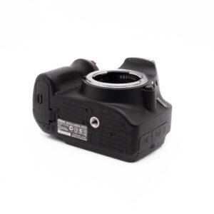 Nikon D3200 kit-4 Nikon D3200 + 18-55mm (SC 3378) - Käytetty kamera näkyy matalasta kulmasta, jolloin pohja, kahva ja objektiivin kiinnitys korostuvat valkoista taustaa vasten.