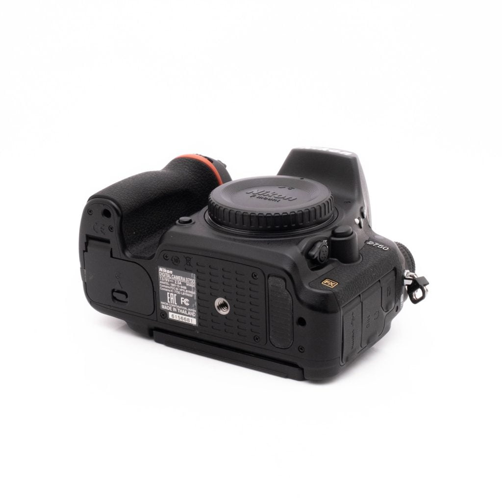 Nikon D750-4 Nikon D750 (SC 101522) - Käytetty musta DSLR-kamera alhaalta katsottuna valkoisella pohjalla, jossa näkyy akkulokero, kahva, jalustakiinnike ja eri portit.