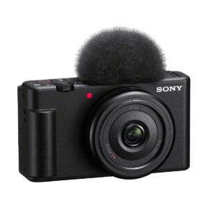 Sony_ZV-1F_003 Sony ZV-1F -kompaktikamera on kompakti musta digitaalikamera, jossa on Zeiss-merkitty objektiivi, ohjauspainikkeet ylä- ja takapuolella sekä irrotettava mikrofonin tuulisuoja ("kuollut kissa").