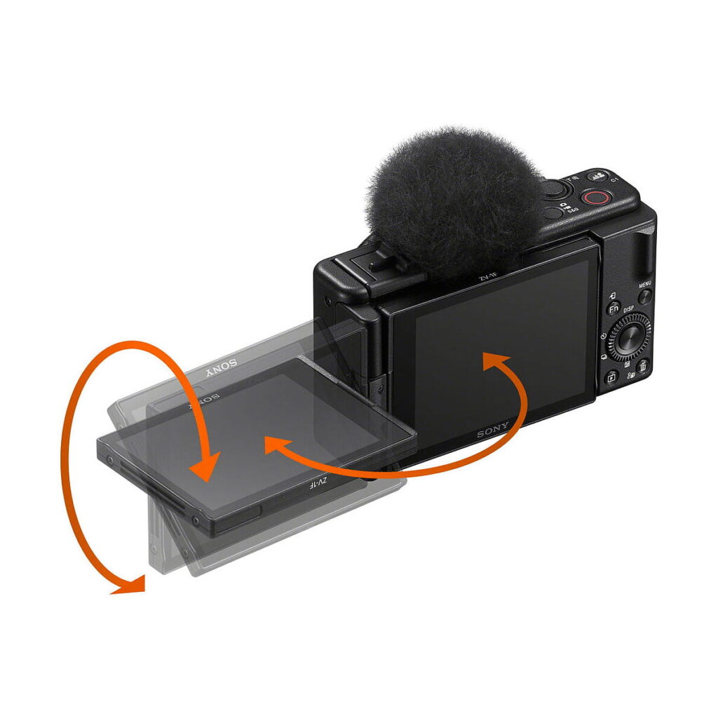 Sony_ZV-1F_007 Sony ZV-1F -kompaktikamera on esitetty mustana, ja sen päällä on sumea mikrofoni, ja oranssit nuolet korostavat ulos käännettävän näytön pyörivää ja kallistettavaa liikettä.