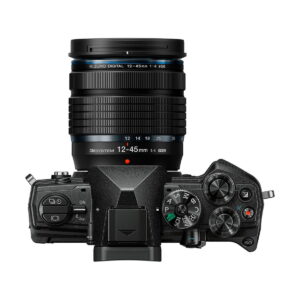 om-5_12-45mm_musta_01 OM SYSTEM OM-5 + 12-45mm f/4 musta kameran ylhäältä katsottuna, jossa on suuri zoom-objektiivi, jossa on merkintä "M.Zuiko Digital 12-45mm 1:4", useita säätöpyöriä, painikkeita, näyttöpaneeli ja erilaisia tila-asetuksia mustassa kamerarungossa.