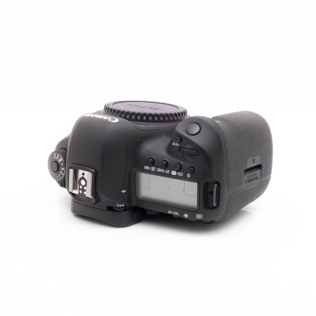 Canon 5DmkIV-4 Musta Canon EOS 5D Mark IV (SC 23300, takuu 6kk, sis.ALV24%) - Käytetty DSLR-runko on kuvattu ylhäältä päin kuvakulmasta, jossa näkyvät painikkeet, LCD-näyttö, toimintatilan valintakiekko ja kuvioitu kahva valkoista taustaa vasten.