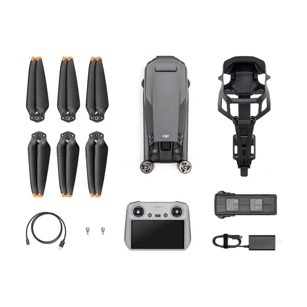 Dji_Mavic_3_RC_Classic_001 Ylhäältä alas näkymä DJI Mavic 3 Classic + DJI RC Ohjain -lennokkipakkauksesta, jossa on taitettu harmaa lennokki, kuusi potkurinlasta, ohjain, kaksi akkua, latauskeskus, kantohihna, USB-kaapeli ja kaksi pientä liitintä.