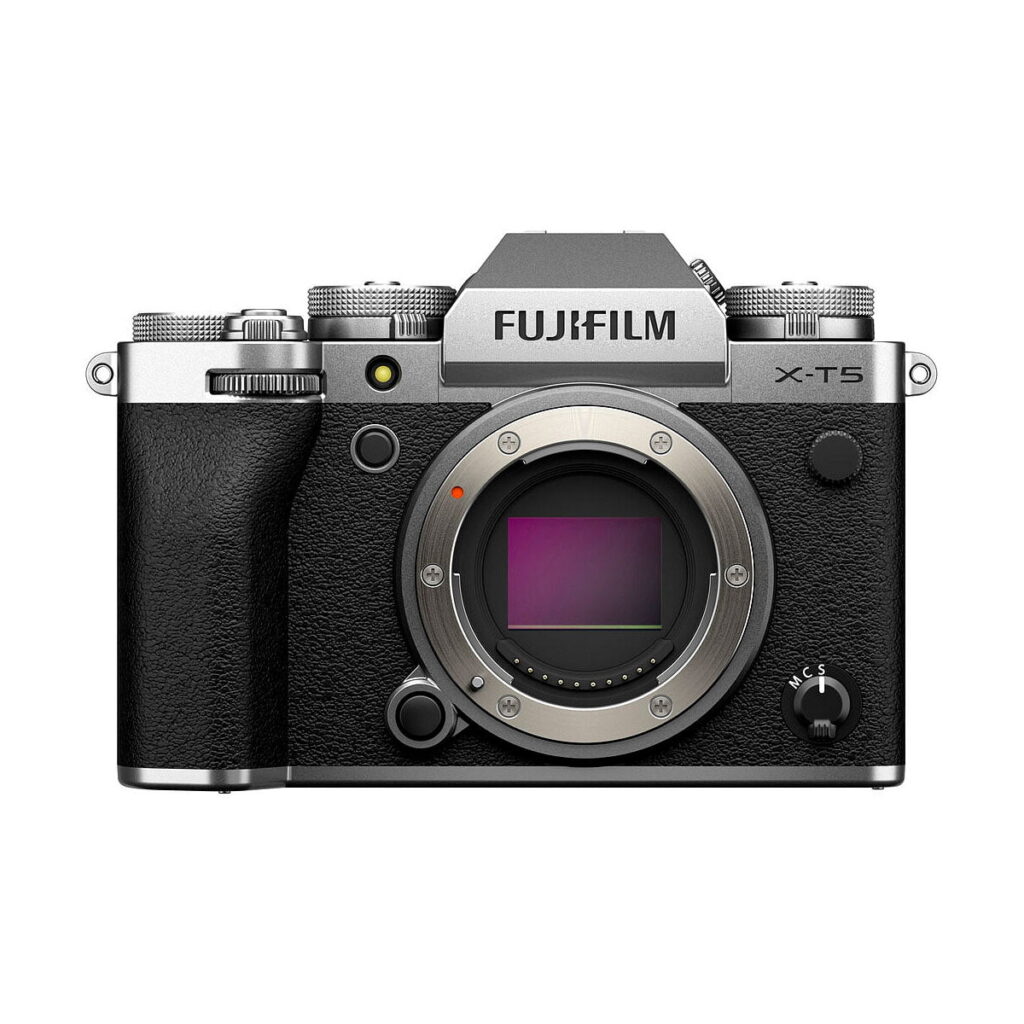 Fujifilm X-T5 -järjestelmäkameran, hopea, peilittömän kameran runko hopean ja mustan värisenä, ilman kiinnitettyä objektiivia, etukuva, jossa näkyy kenno ja säätimet.