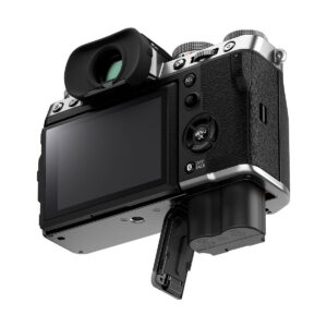 Fuji_X-T5_Hopea_003 Fujifilm X-T5 -järjestelmäkamera, hopea näkyy takaa ja alhaalta LCD-näyttö näkyvissä, akkulokero auki ja osittain irrotettu akku. Kamerassa on musta ja hopeinen runko, jossa on kuvioitu kahva.