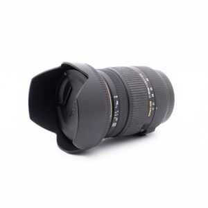 Sigma 17-50 Canon-1 Sigma DC 17-50mm f/2.8 EX HSM OS Canon - Käytetty musta kameraobjektiivi, jossa on vastavalosuoja, zoomaus- ja tarkennusrenkaat, näkyy valkoisella taustalla.