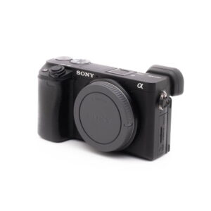 Sony a6500-1-2 Sigma DC 17-50mm f/2.8 EX HSM OS Canon EF-S -objektiivi (käytetty) kuvattuna kulmassa valkoisella taustalla, molemmat objektiivin suojukset kiinnitettyinä.