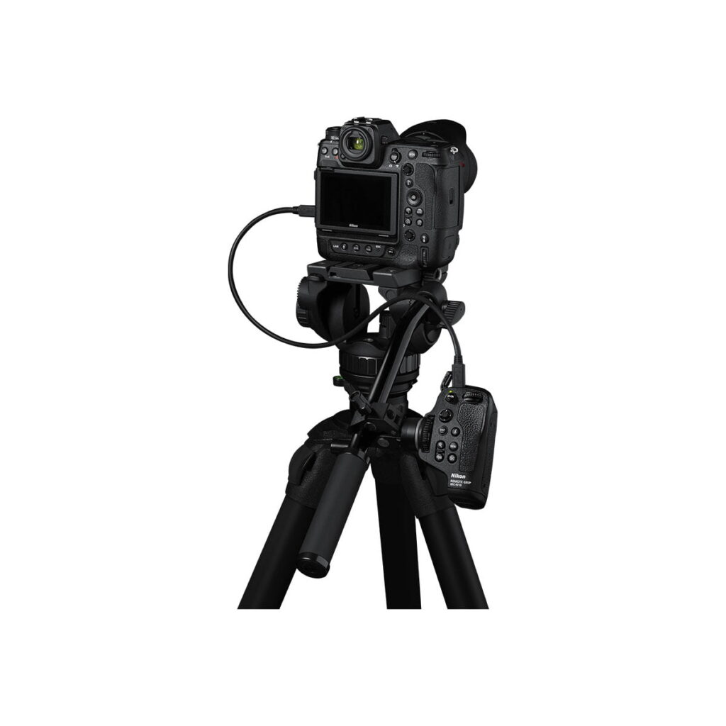 nikon_mc_n10_01 Jalustalla oleva digitaalikamera liitetään kaapeleilla Nikon MC-N10 kauko-ohjauskahvaan, joka on kiinnitetty yhteen jalustan jaloista. Kameran takanäyttö ja ohjauspainikkeet ovat näkyvissä.