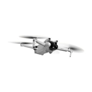 DJi_Mini_3_RC_Combo_002 DJI Mini 3 + Smart Controller -lennokki, jossa on tyylikäs valkoinen muotoilu, neljä pidennettyä käsivartta ja pyörivät potkurit, lentää valkoista taustaa vasten. Etukamera lisää sen kompaktia ja modernia ulkonäköä.