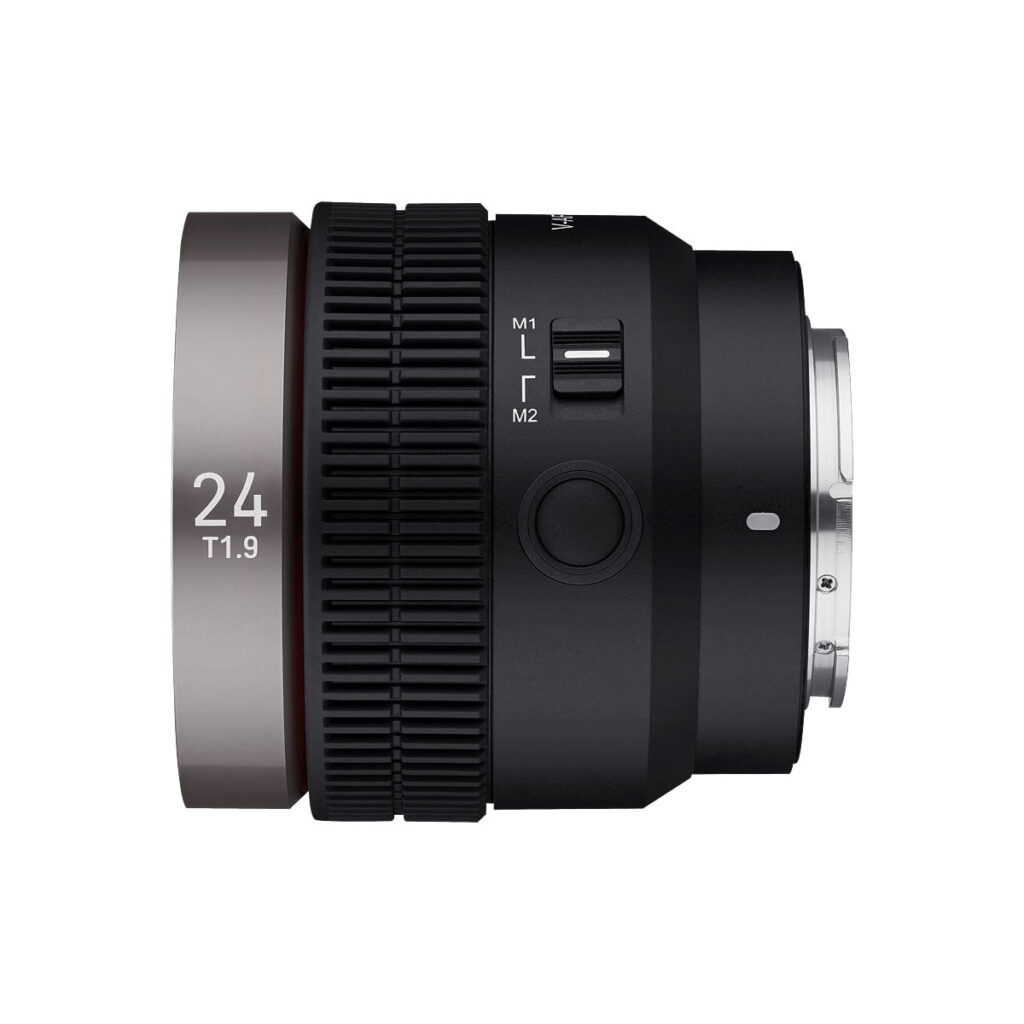 Samyang_V-AF_24mm_T1_9-Sony_FE_003 Samyang V-AF 24mm T1.9 -objektiivin sivukuva Sony FE:hen näyttää mustan rungon, jossa on suuri tarkennusrengas, jossa on merkintä 24 T1.9, kytkimet, joissa on merkinnät M1, L ja M2, ja metallinen kiinnike oikealla.