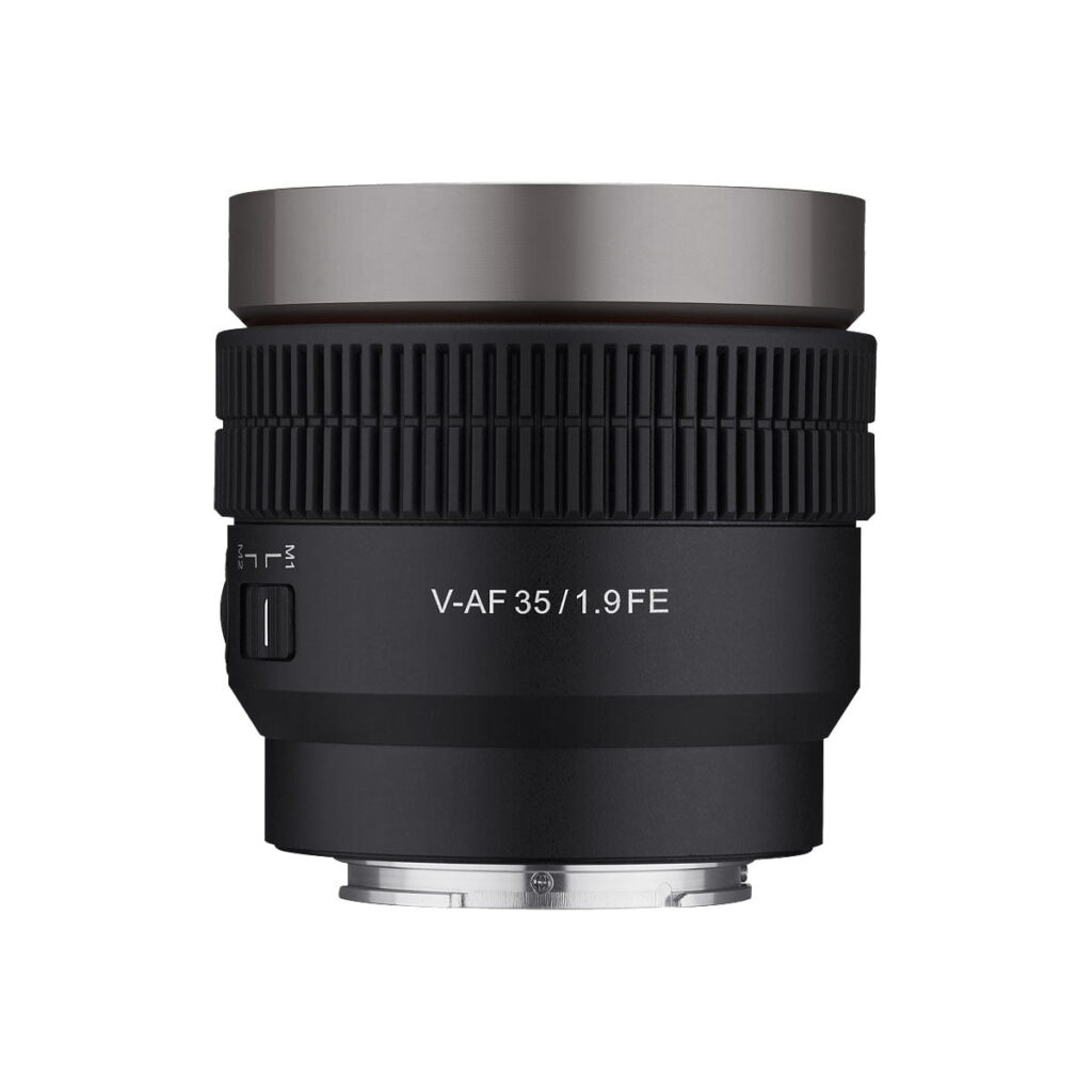 Samyang_V-AF_35mm_T1_9-Sony_FE_001 Musta Samyang V-AF 35mm T1.9 -objektiivi Sony FE:hen näkyy valkoista taustaa vasten, ja siinä on metallinen hopeinen rengas yläosassa sekä uurrettu tarkennus- ja säätörengas.