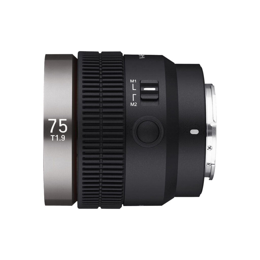 Samyang_V-AF_75mm_T1_9-Sony_FE_003 A close-up side view of the Samyang V-AF 75mm T1.9 - Sony FE lens shows the 75 T1.9 marked on a silver ring, a textured focus ring, M1/M2 mode switch and a smooth black finish against a white background.