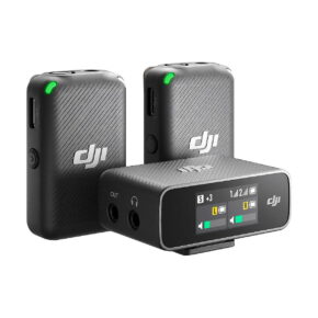 DJi_Mic_001 The DJI Mic Dual Kit wireless microphone system includes two black transmitters with green LEDs and a receiver with a display and multiple audio ports.