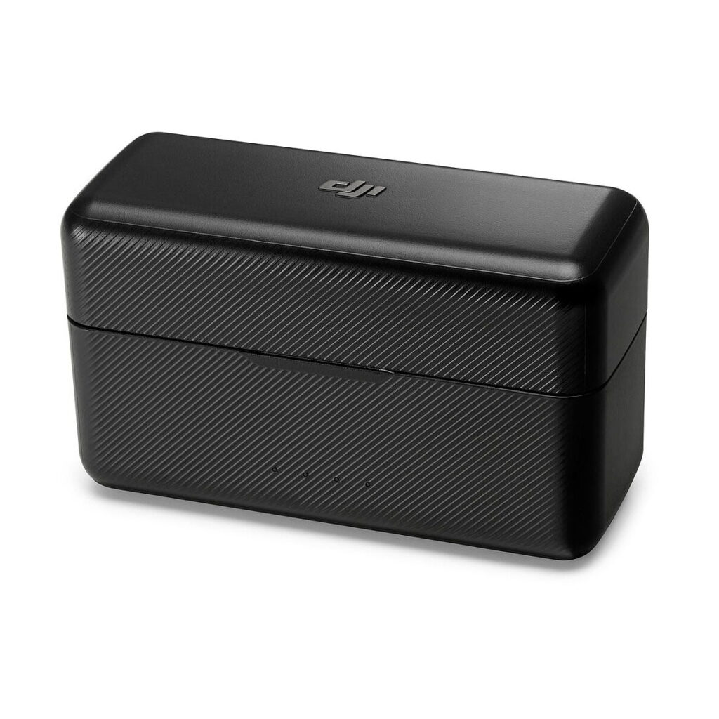 DJi_Mic_003 Musta suorakaiteen muotoinen DJI Mic Dual Kit -langaton mikrofonijärjestelmä -latauskotelo, jossa on kuvioitu pinta ja pyöristetyt reunat valkoista taustaa vasten.