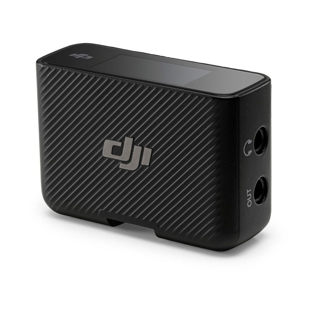 DJi_Mic_004 DJI Mic Dual Kit -langaton mikrofonijärjestelmä on kompakti musta lähetin, jossa on kuvioitu diagonaalinen raidallinen muotoilu, kaksi 3,5 mm:n tulo-/lähtöporttia, pieni yläosan näyttö ja DJI-logo sivulla.