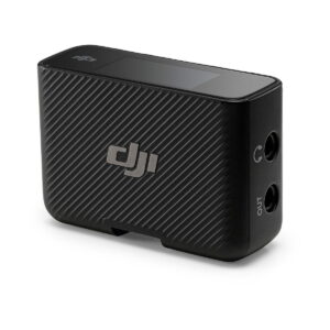 DJi_Mic_004 DJI Mic Dual Kit -langaton mikrofonijärjestelmä on kompakti musta lähetin, jossa on kuvioitu diagonaalinen raidallinen muotoilu, kaksi 3,5 mm:n tulo-/lähtöporttia, pieni yläosan näyttö ja DJI-logo sivulla.