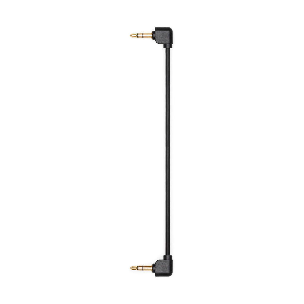DJi_Mic_006 DJI Mic Dual Kit -langaton mikrofonijärjestelmä sisältää mustan äänikaapelin, jonka molemmissa päissä on kullatut 3,5 mm:n kulmaliittimet, jotka näkyvät pystysuorassa valkoista taustaa vasten.