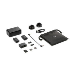 DJi_Mic_011 DJI Mic Dual Kit -langaton mikrofonijärjestelmä esillä valkoisella taustalla: kaksi lähetintä, yksi vastaanotin, tuulisuojaimet, latauskotelo, kaapelit, adapterit, microSD-kortit ja musta kiristysnyöripussi.