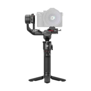 DJi_RS_3_Mini_003 The DJI RS 3 Mini gimbal, a handheld gimbal with a digital camera mounted on it, is shown on a small tripod against a white background. The handle features controls and a brand logo for ease of use.