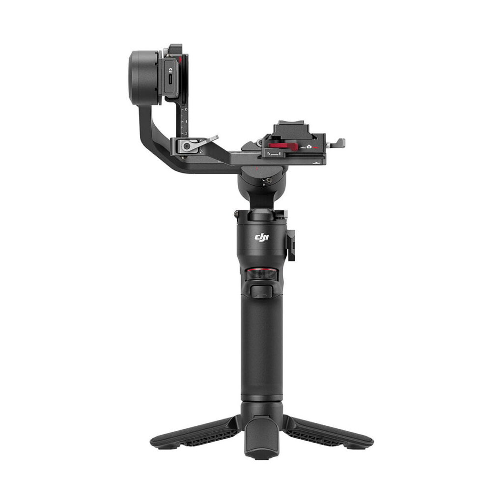 DJi_RS_3_Mini_004 The DJI RS 3 Mini gimbal is a black handheld camera stabilizer with a stand designed to support and stabilize cameras for smooth video shooting.
