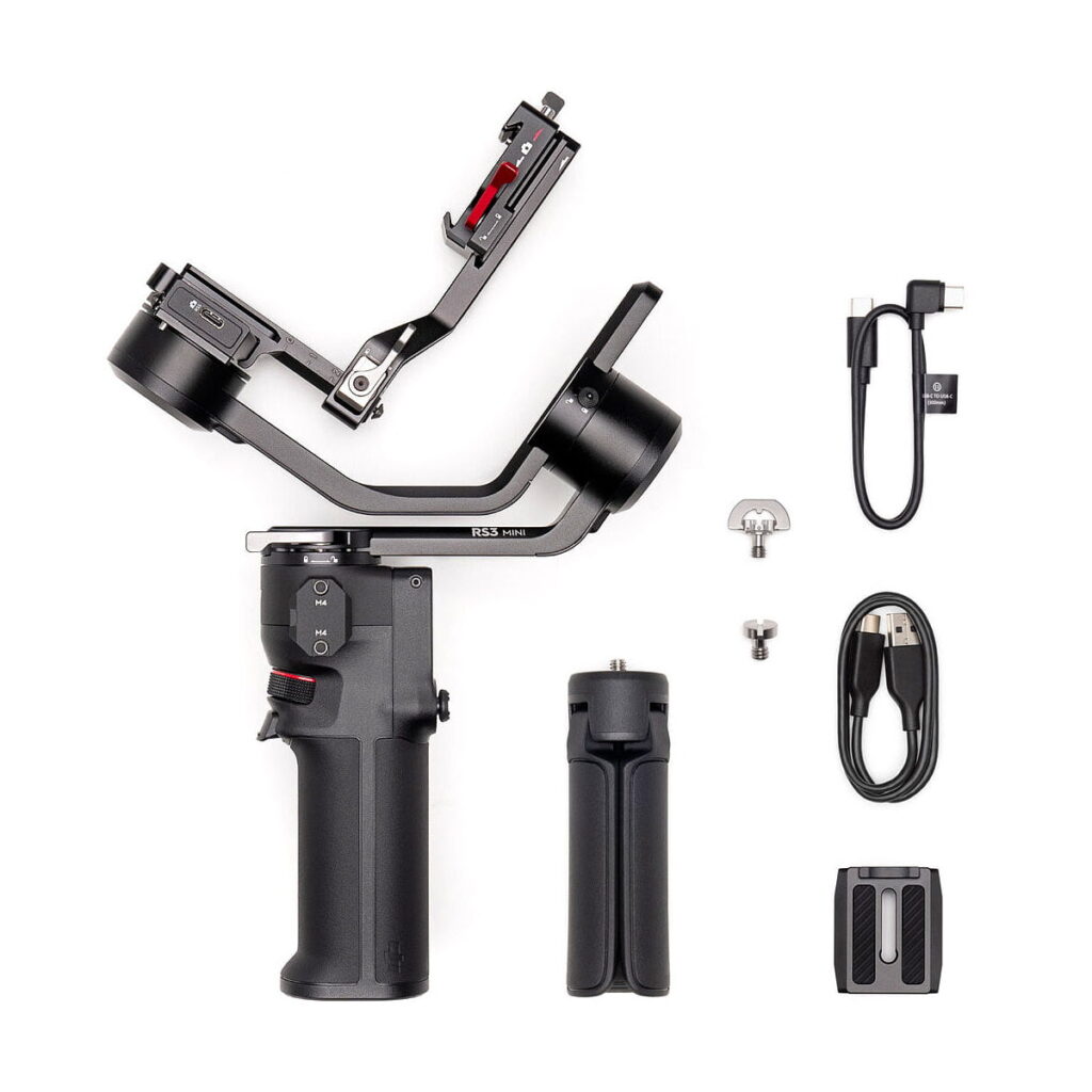 DJi_RS_3_Mini_008 The DJI RS 3 Mini gimbal with detachable handle, tripod stand, mounting accessories and USB cables is neatly displayed on a white background.