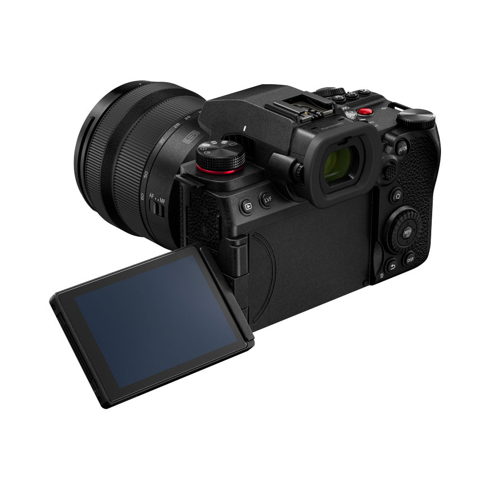lumix_s5ii_20-60mm_03 Panasonic Lumix S5 II + 20-60mm f/3.5-5.6 näkyy takaa suurine linsseineen, monine painikkeineen, mustana kuvioitu kahva ja sivulle käännetty LCD-näyttö.