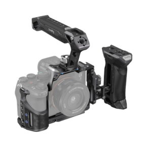 smallrig_3710_01 SmallRig 3710 Rhinoceros Advanced Cage Kit for Sony A7 RV/A7VI/A7SIII -mallissa on Sony Alpha -kamera, jossa on yläkahva ja irrotettava oikeanpuoleinen kahva. Läpinäkyvä kamera ja objektiivi korostavat häkin lisävarusteita.