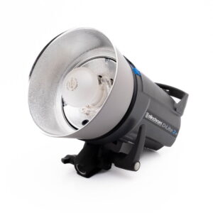 Elinchrom D-Lite 2 it-1 Elinchrom D-Lite 2 it - Käytetty studiostroboskooppivalaisin, jossa on hopeinen heijastin ja valotettu lamppu, on asetettu kyljelleen valkoista taustaa vasten.