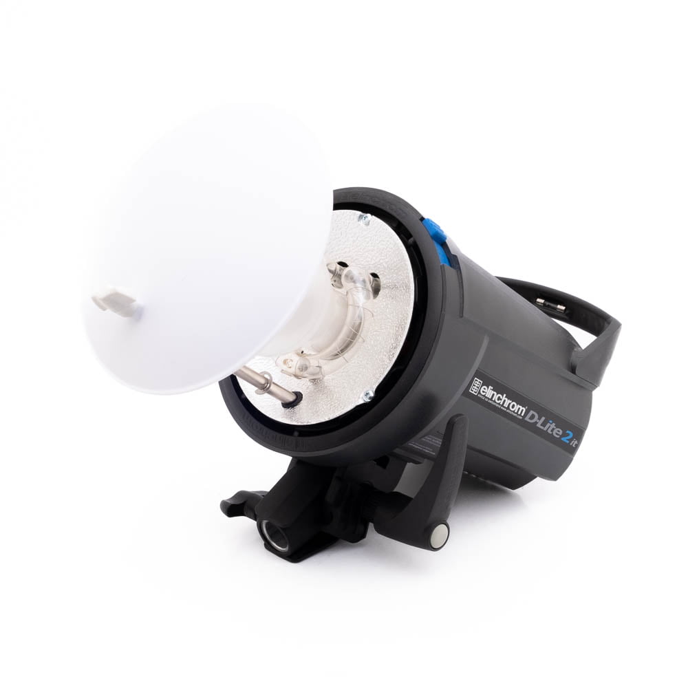 Elinchrom D-Lite 2 it-2 Elinchrom D-Lite 2 it - Käytetty studiostrobovalaisin, jossa on valkoinen heijastinlautas, on kulmautettu kiinnikkeellä valkoista taustaa vasten.