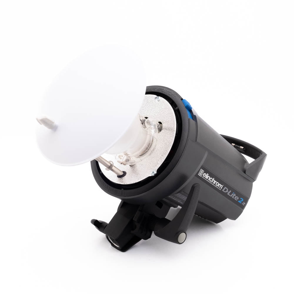 Elinchrom D-Lite 2 it-5 Elinchrom D-Lite 2 it - Käytetty studiostrobovalaisin on kuvattu kyljellään valkoisella diffuusorilla kiinnitettynä, mustalla rungolla ja metalliheijastimella, eristettynä valkoiselle taustalle.
