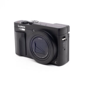 Panasonic DC-TZ90 7657-5 Musta Panasonic Lumix DC-TZ90 - Käytetty -digitaalikamera näkyy valkoisella taustalla, ja sen Leica-objektiivi, ergonominen kahva ja sivusäätimet korostuvat.