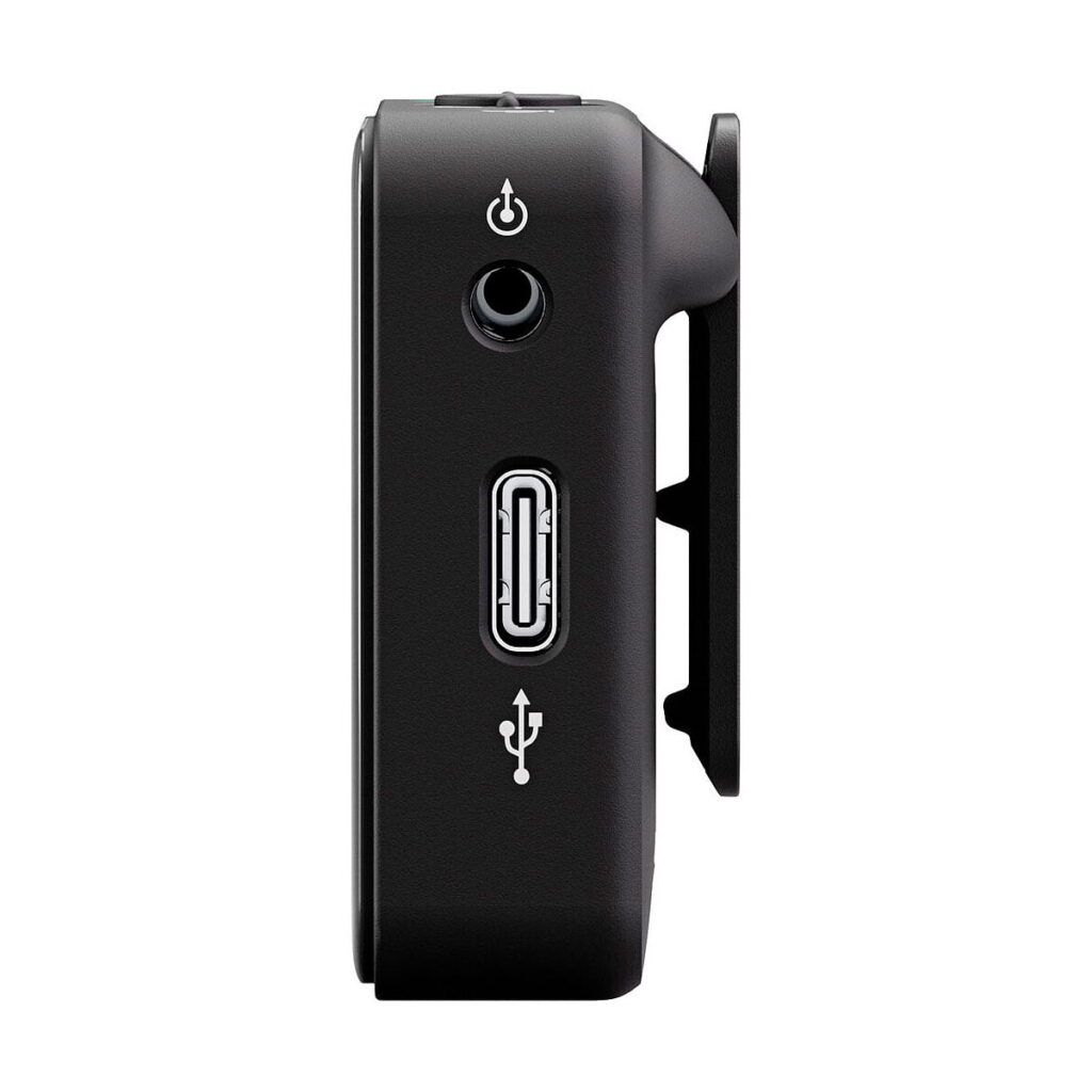 Sivukuva Rode Wireless ME -langaton mikrofonijärjestelmä mustana, jossa on virtapainike, pyöreä portti ja USB-portti. Oikealla puolella on klipsikiinnitys valkoista taustaa vasten.