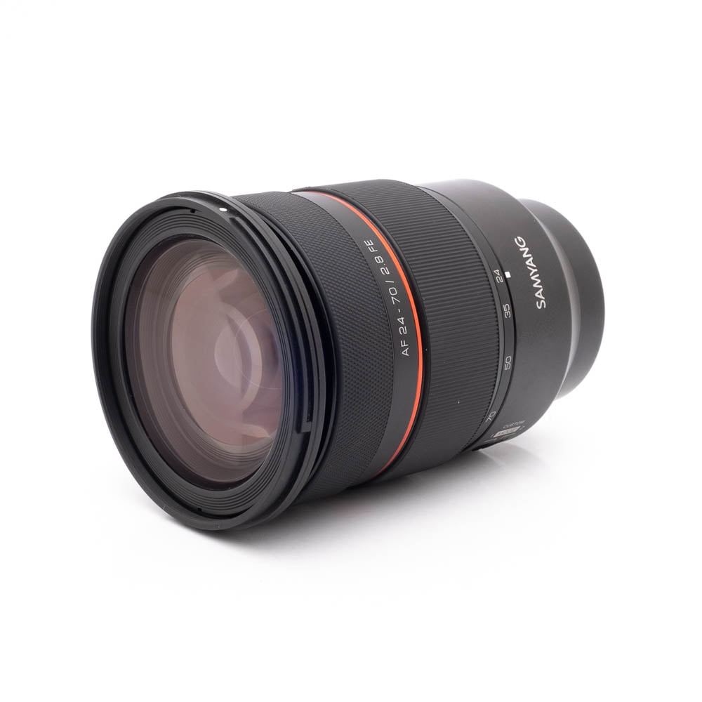 Samyang 24-70mm f28 FE Canon-2 Panasonic Lumix DC-TZ90 - Käytetty kamera on esillä valkoisella pohjalla, ja se on suunnattu niin, että objektiivin ja rungon yksityiskohdat tulevat esiin.