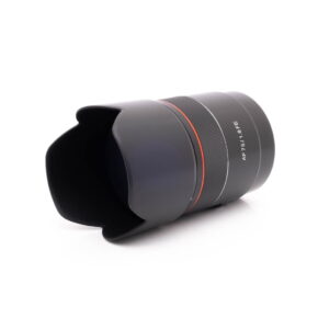 Samyang 75mm f18 FE Canon-3 Panasonic Lumix DC-TZ90 - Käytetty kameran objektiivi, jossa on vastavalosuoja ja erottuvat merkinnät, istuu valkoisella taustalla.