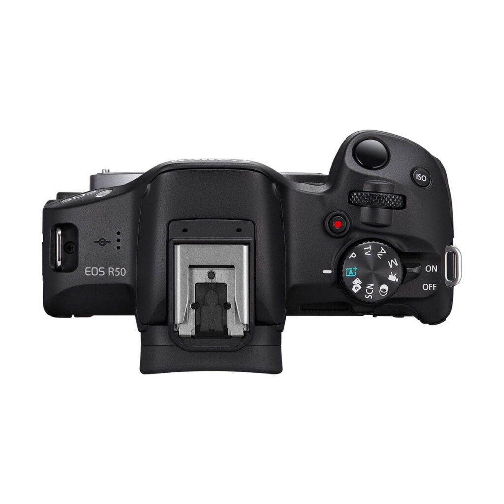 canon_r50_runko_02 Canon EOS R50 system camera - 100€ discount - top view, highlighting the selection dial, shutter button, power switch, ISO button, hot shoe mount and various controls and ports on the camera.