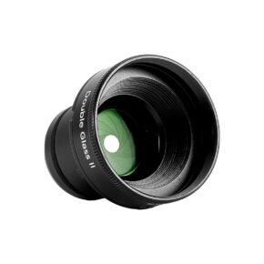 lensbaby_double_glass_II_optic Musta Lensbaby Double Glass II Optic -kameran linssi, jossa on näkyvä vihreällä sävytetty lasielementti valkoista taustaa vasten.