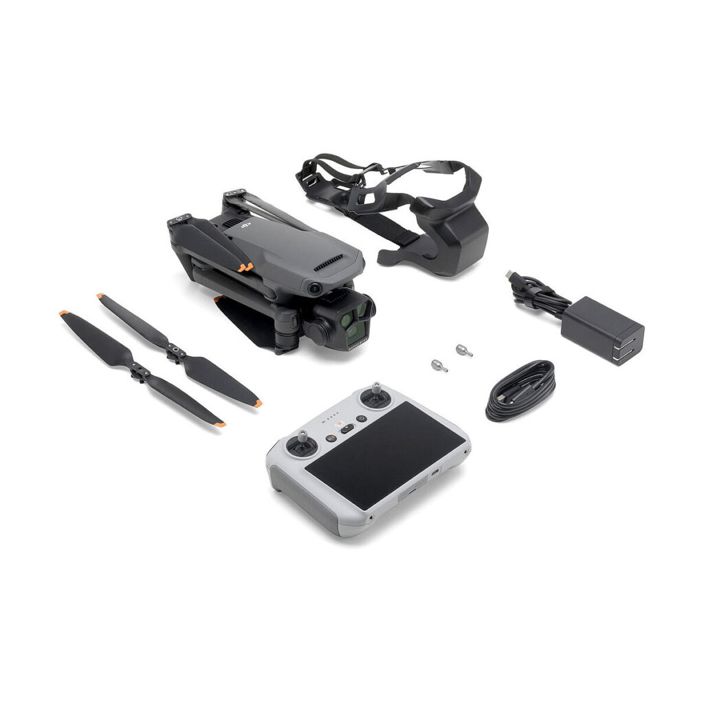 DJI_Mavic_3_Pro_002 Mustan värinen DJI Mavic 3 Pro + DJI RC Ohjain -lennokki näkyy taitettuna kameran, kuulokkeiden, kahden potkurinlavan, ruuvien, harmaalla näytöllä varustetun kauko-ohjaimen, virtalähteen ja latauskaapelin kanssa valkoisella pohjalla.