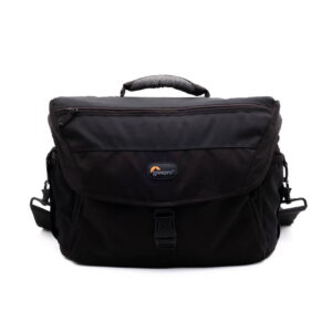 Lowepro Nova 200 AW-2 Käytetty Lowepro Nova 200 AW musta kameralaukku, jossa on etuläppä, yläkahva, sivuhihnat ja näkyvä logo. Tukeva muotoilu ihanteellinen kameravarusteiden kuljettamiseen.