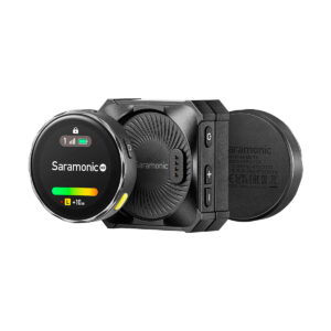 Saramonic_Blink_ME_B2_011 Saramonic BlinkMe B2 -langaton mikrofonijärjestelmä on kompakti musta langaton mikrofonijärjestelmä, jossa on signaalin ja akun pyöreä näyttö, joka on kiinnitetty suorakulmaiseen vastaanottimeen, jossa on painikkeet ja Saramonicin tuotemerkki.