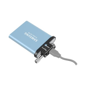 smallrig_3300_03 SmallRig 3300 Cable Clamp T5 SSD for BMPCC 6K PRO pitää sinistä Samsung Portable SSD T5 -levyä, joka on liitetty harmaalla kaapelilla pieneen mustaan ORICO-sovittimeen.